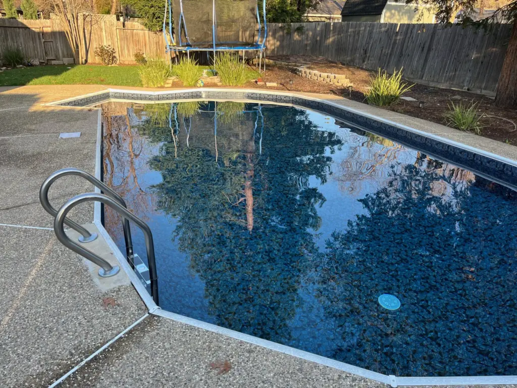 After: the same pool with a new dark patterned liner and clear water, photographed March 17, 2023