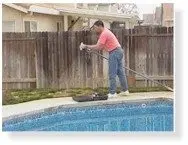 Assembling the leak detector on its telescopic pole beside the pool