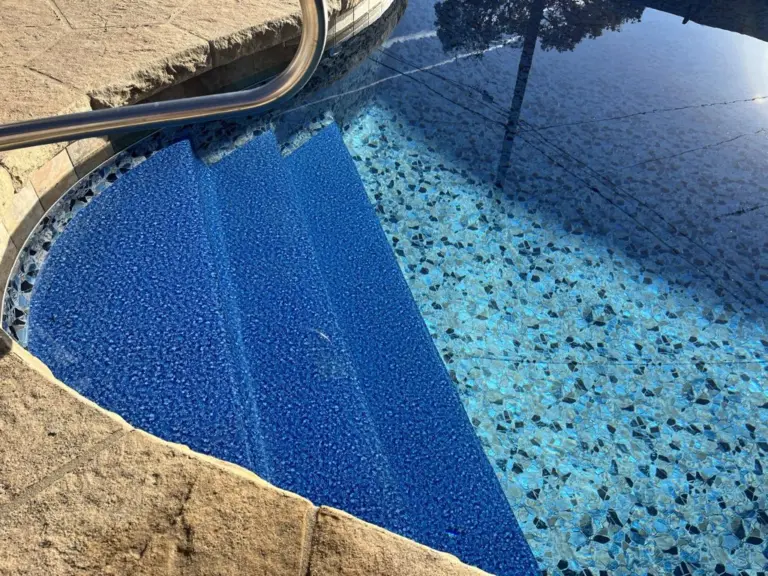 Corner steps in a pool with a speckled pebble-pattern liner and a dark border