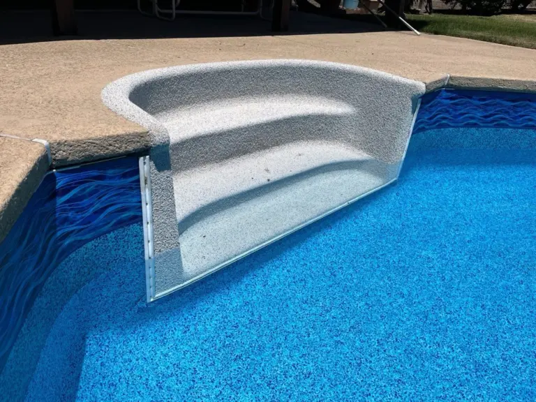 Curved steps coated in light gray Rebound beside a bright blue liner with a wave border