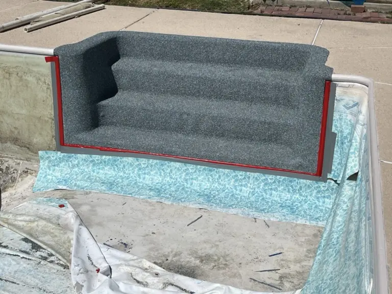 Fiberglass steps resurfaced in gray Rebound, edged in red tape, in a drained pool