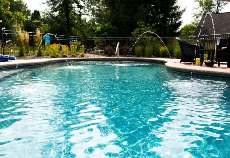 Pool in the Savannah liner with arching water features and a black fence