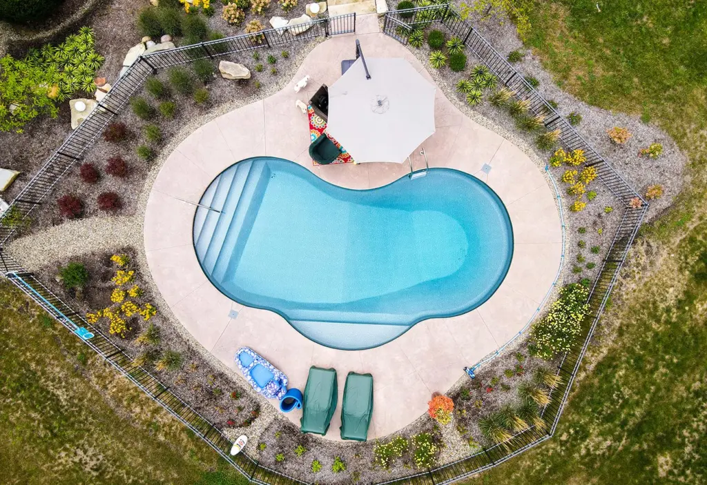 Aerial view of a kidney-shaped pool in the Savannah liner, lounge chairs on the deck
