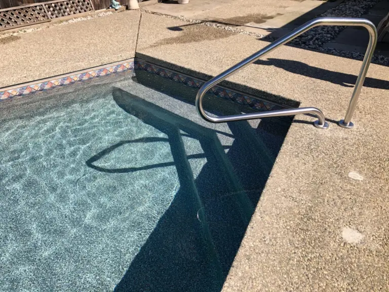 The new steps from the deck, the stainless handrail casting a shadow across the water