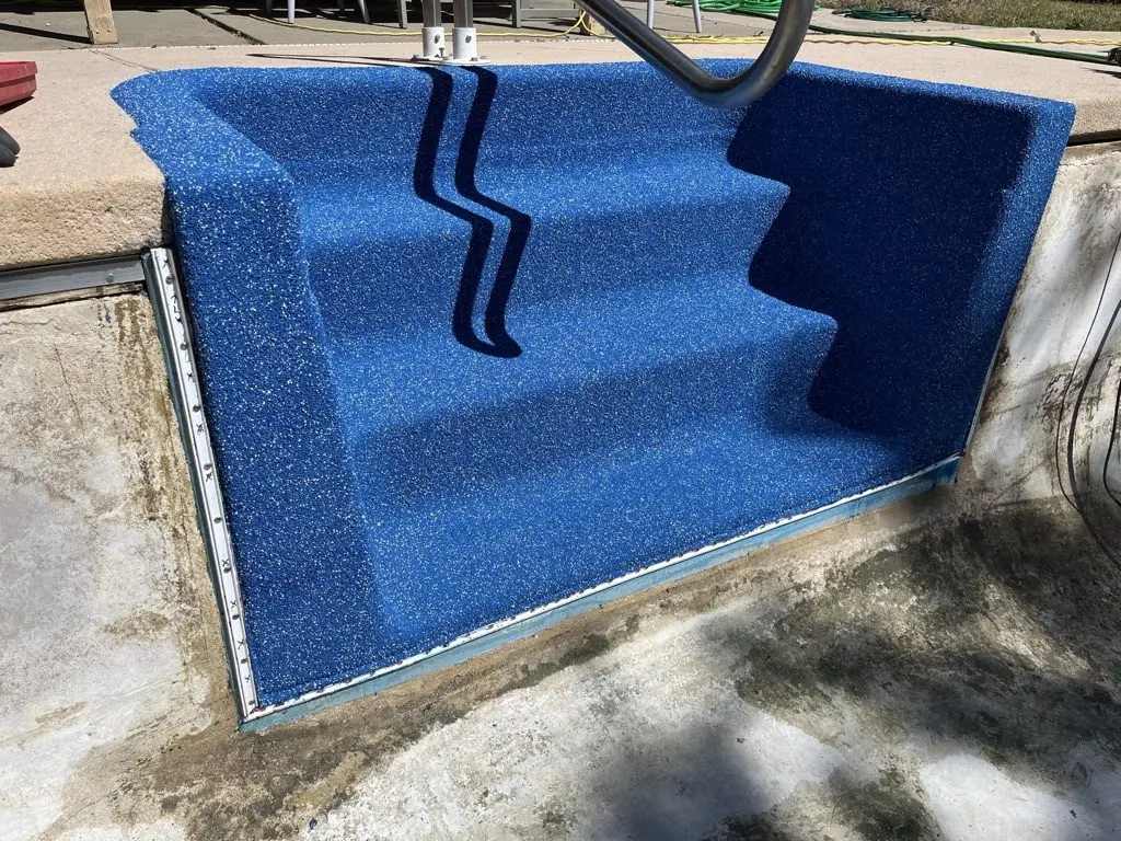 Vinyl-over steps with a handrail, the new liner fitted over every tread before the pool is filled