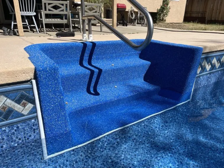 Vinyl-over steps with a handrail, a diamond tile border running along the wall